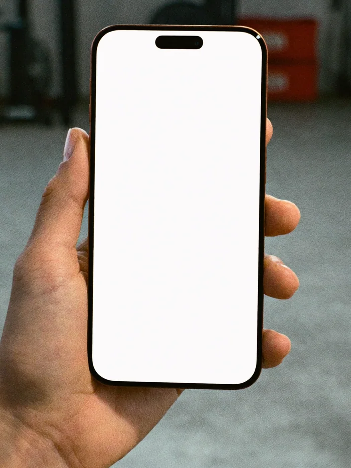 A hand holding a phone with the FORMA website open on it